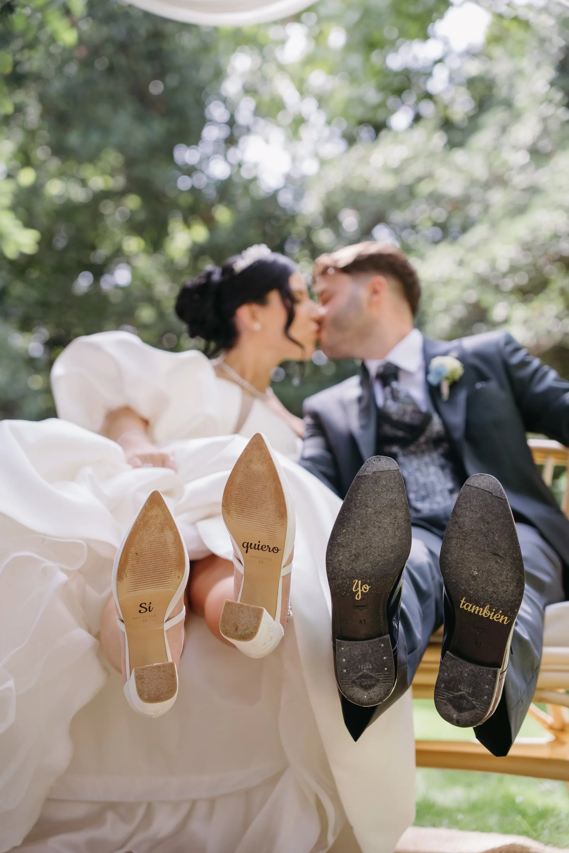 Los novios besándose con las suelas de los zapatos a la vista, con un «sí quiero» escrito
