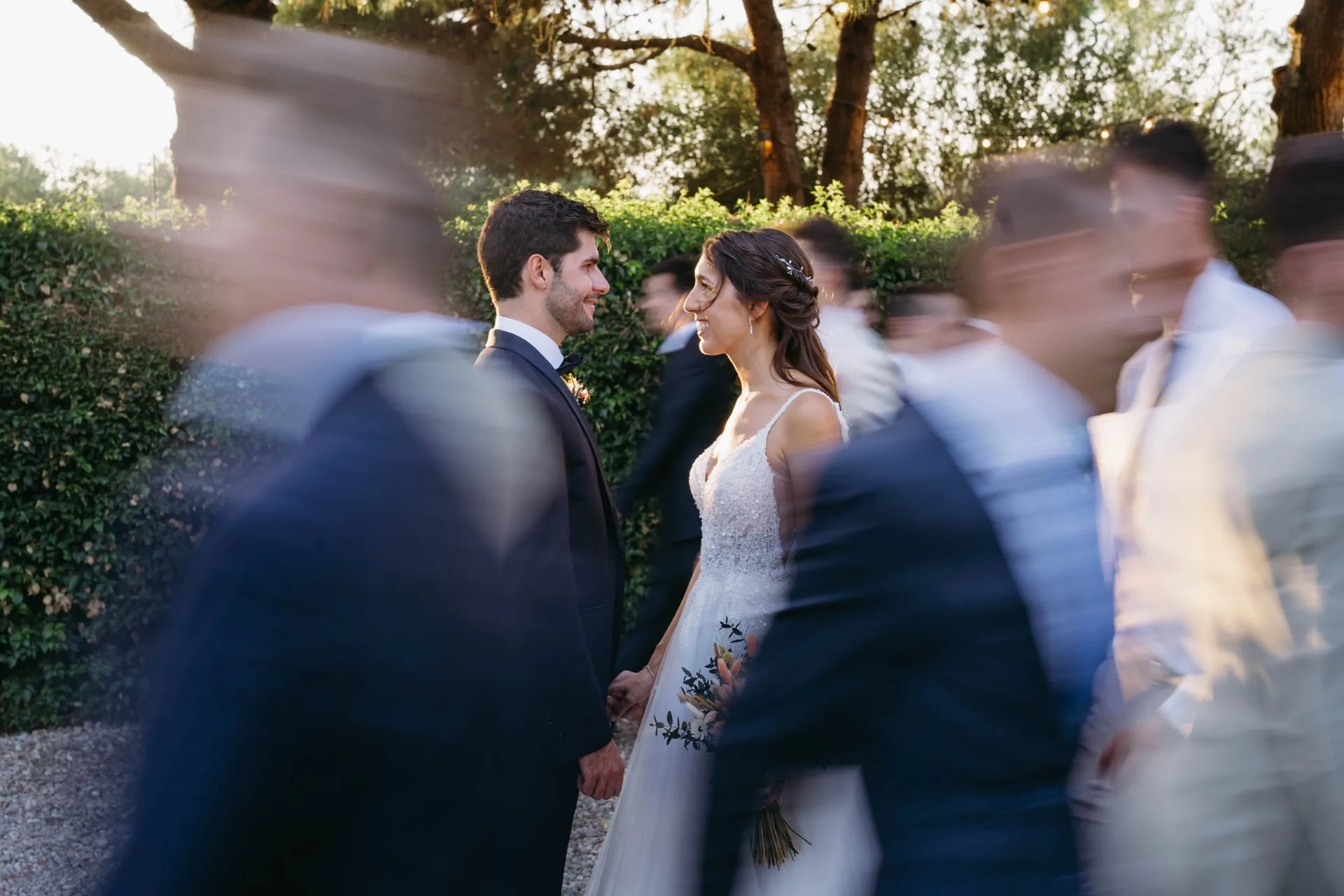 Los novios quietos mientras los invitados pasan a su alrededor