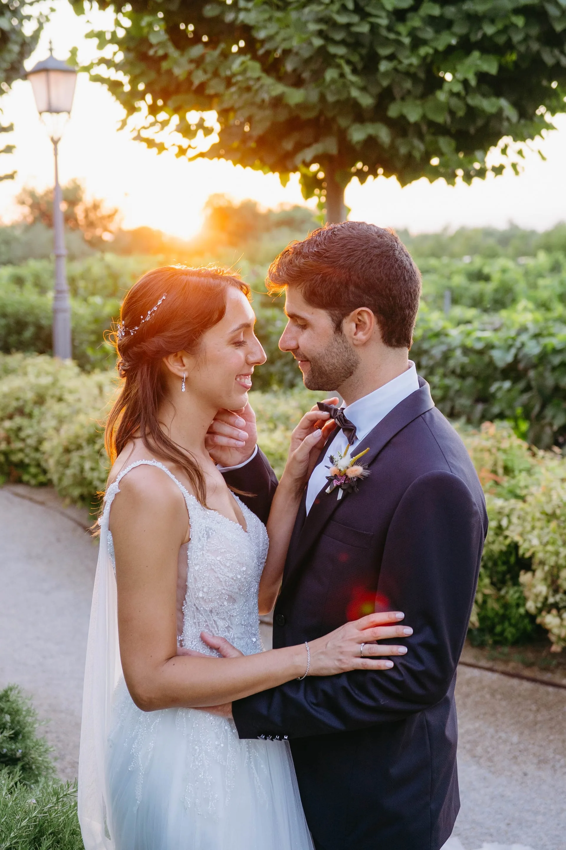 Retrato de los novios abrazados con el sol poniéndose detrás, en plena hora dorada